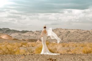 bride in wedding dress standing in wilderness