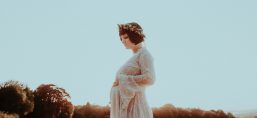 young pregnant woman in grassy field