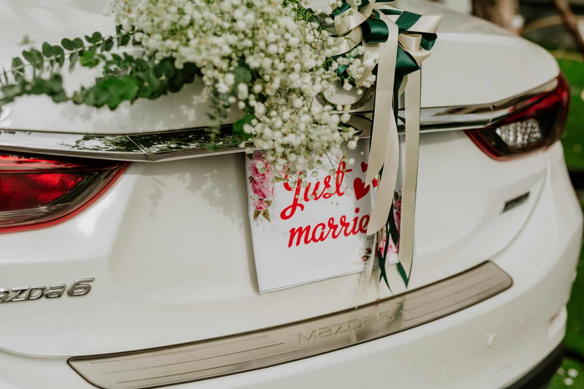 modern car decorated with bridal bouquet and inscription