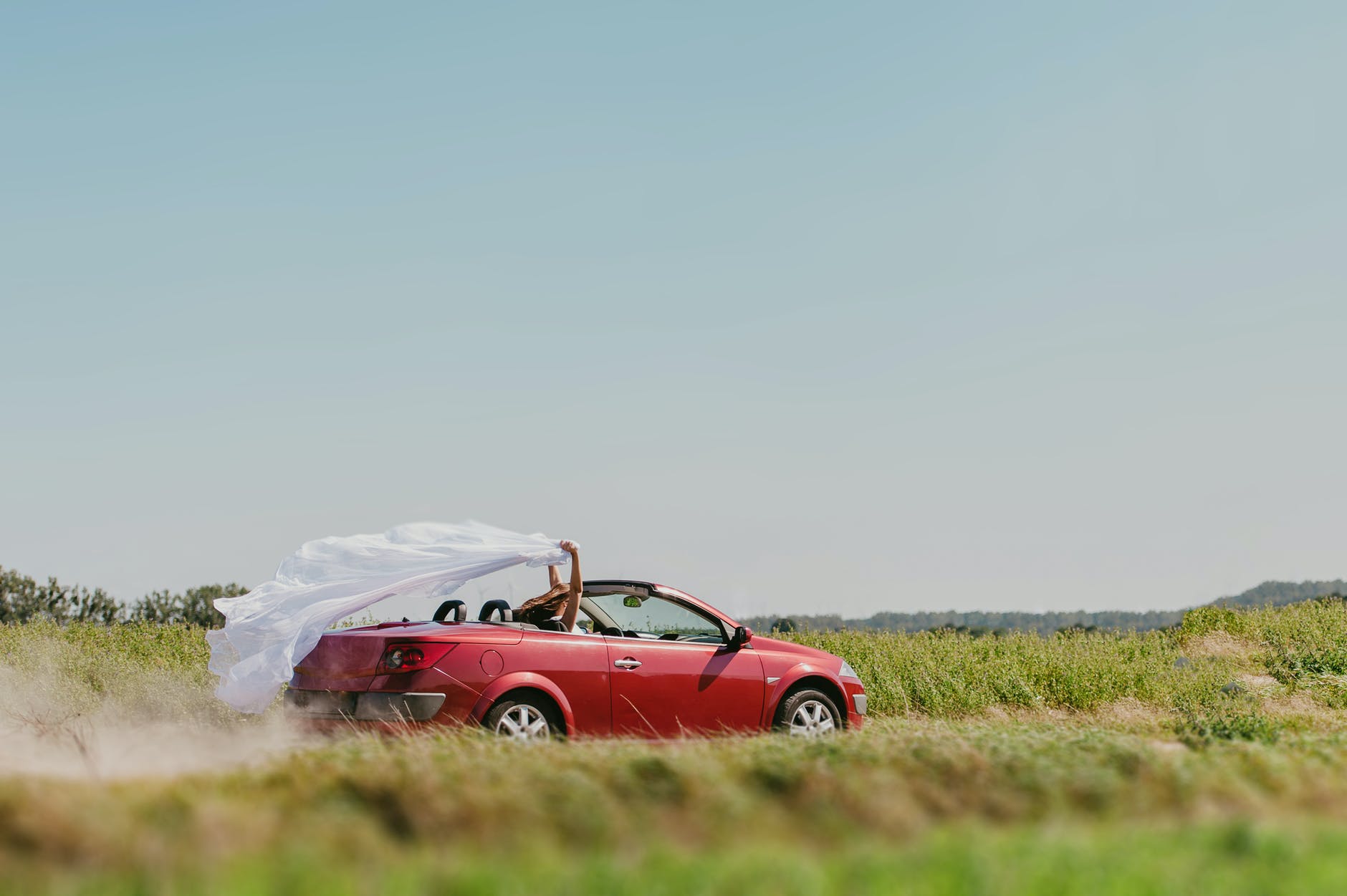 happy woman with veil in cabriolet