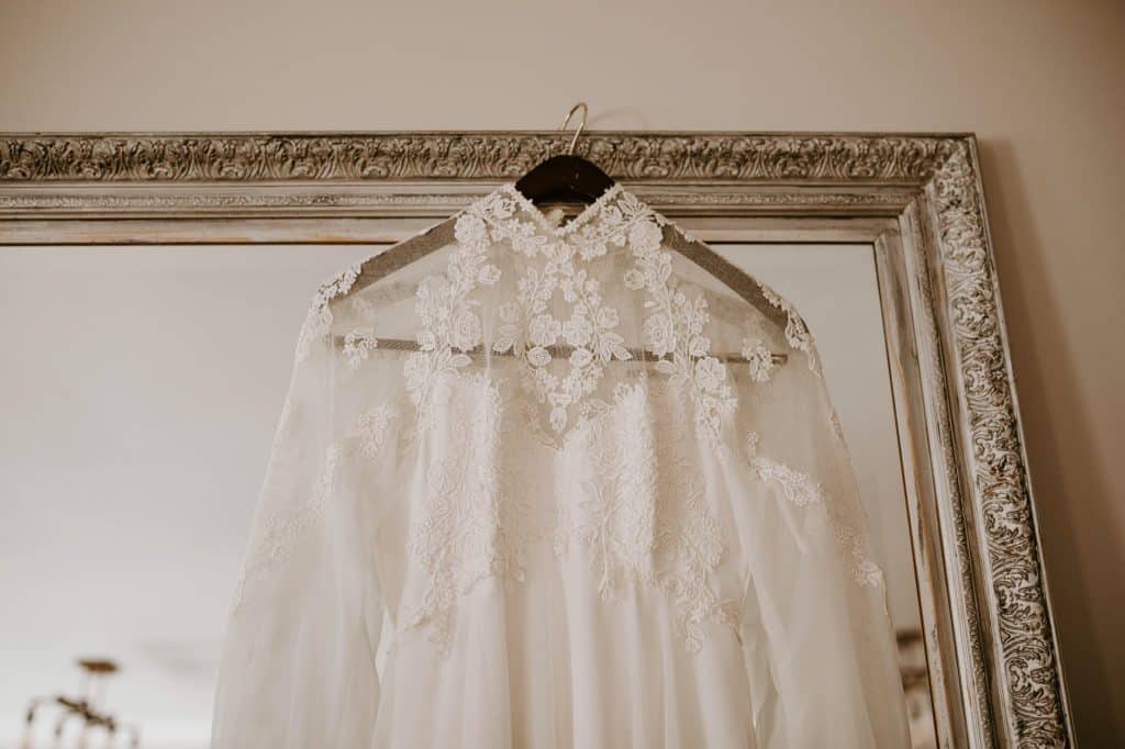 elegant bridal dress hanging on mirror