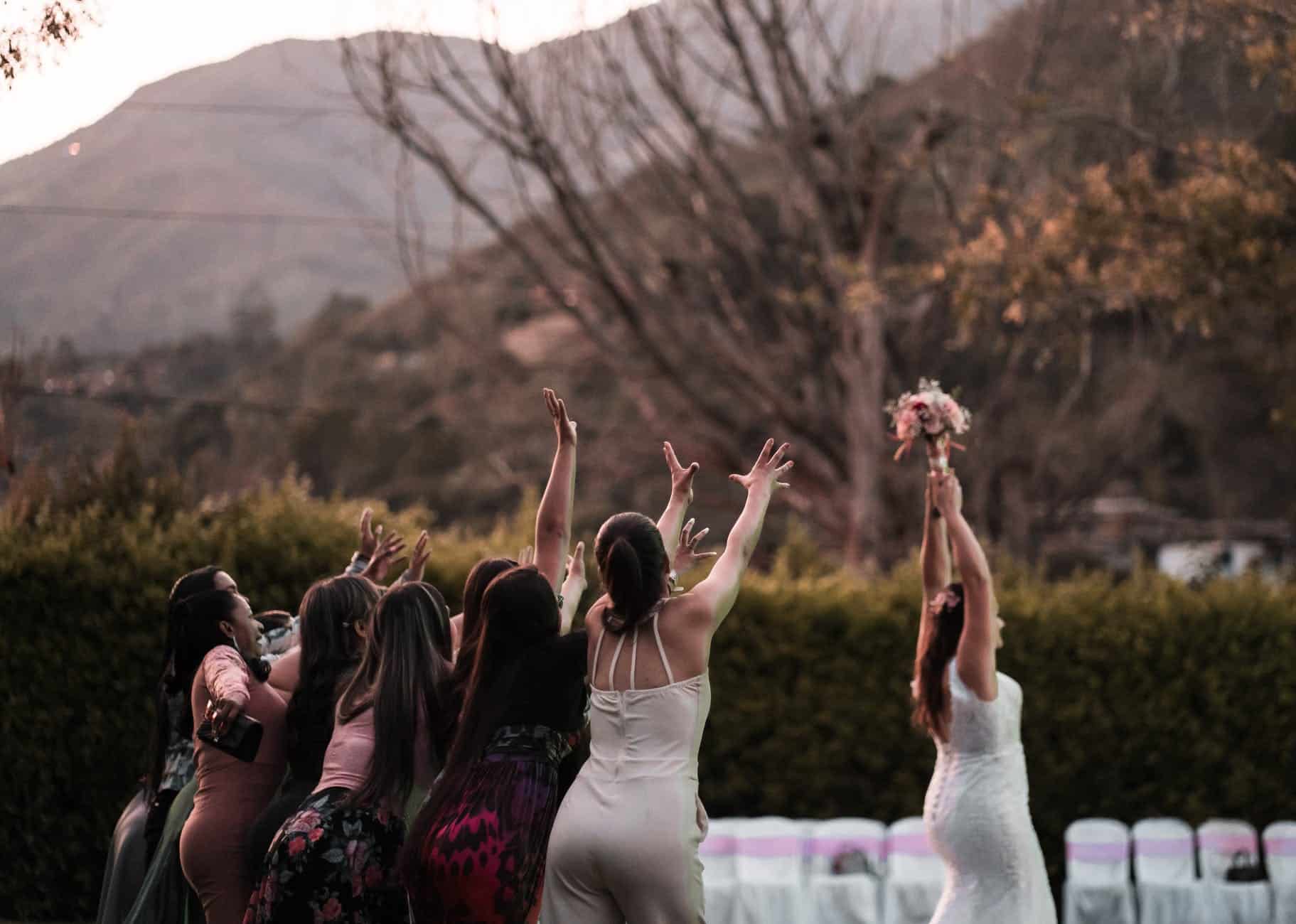 woman throwing bouquet to bridesmaids