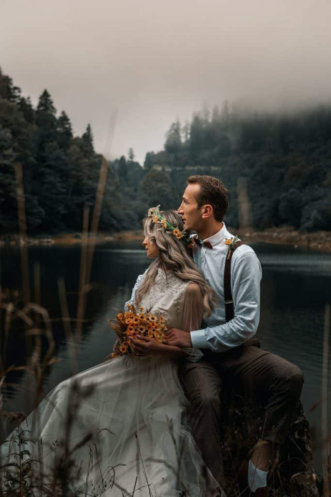 newlywed couple hugging on lakeside
