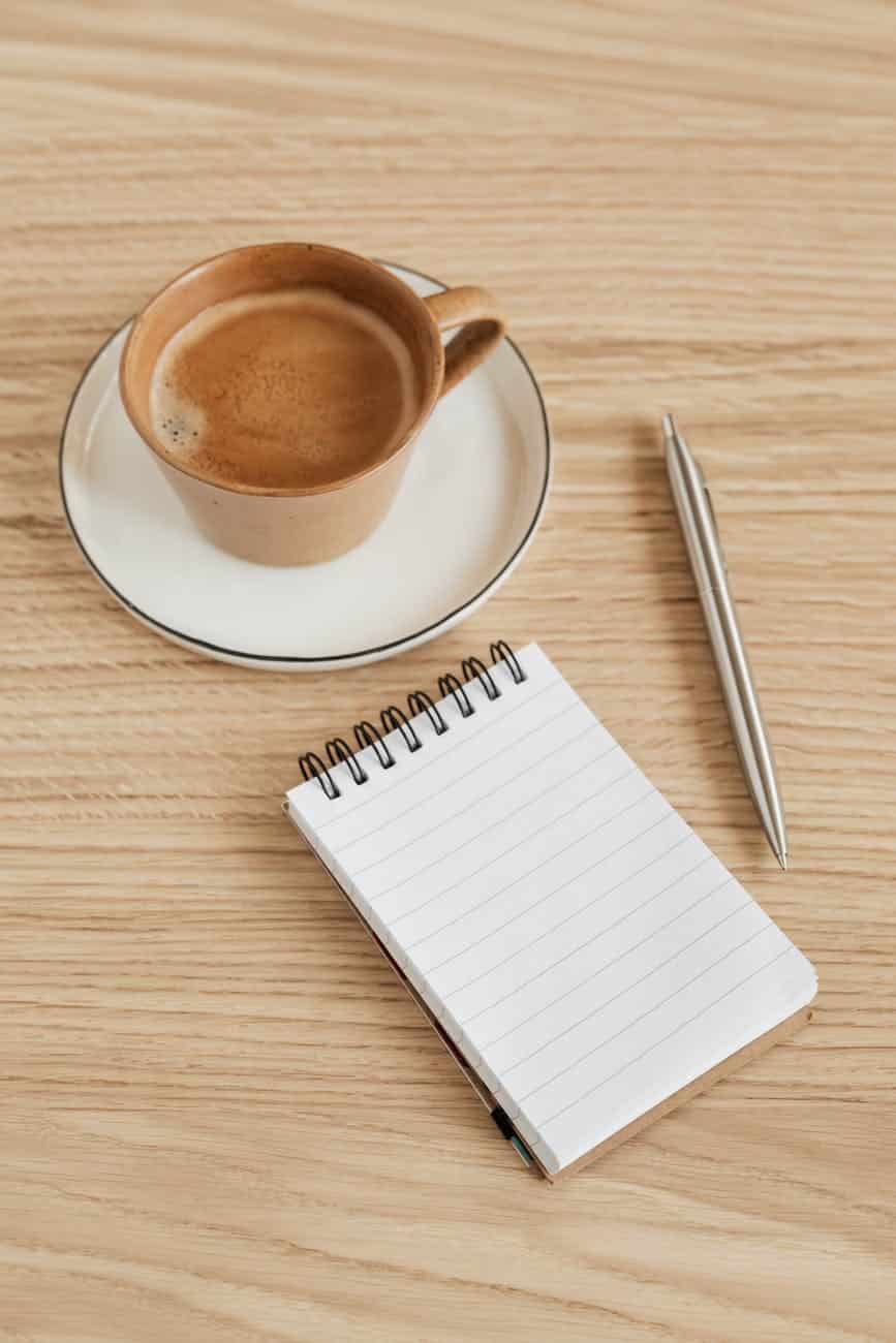 cup of coffee and notebook with pen