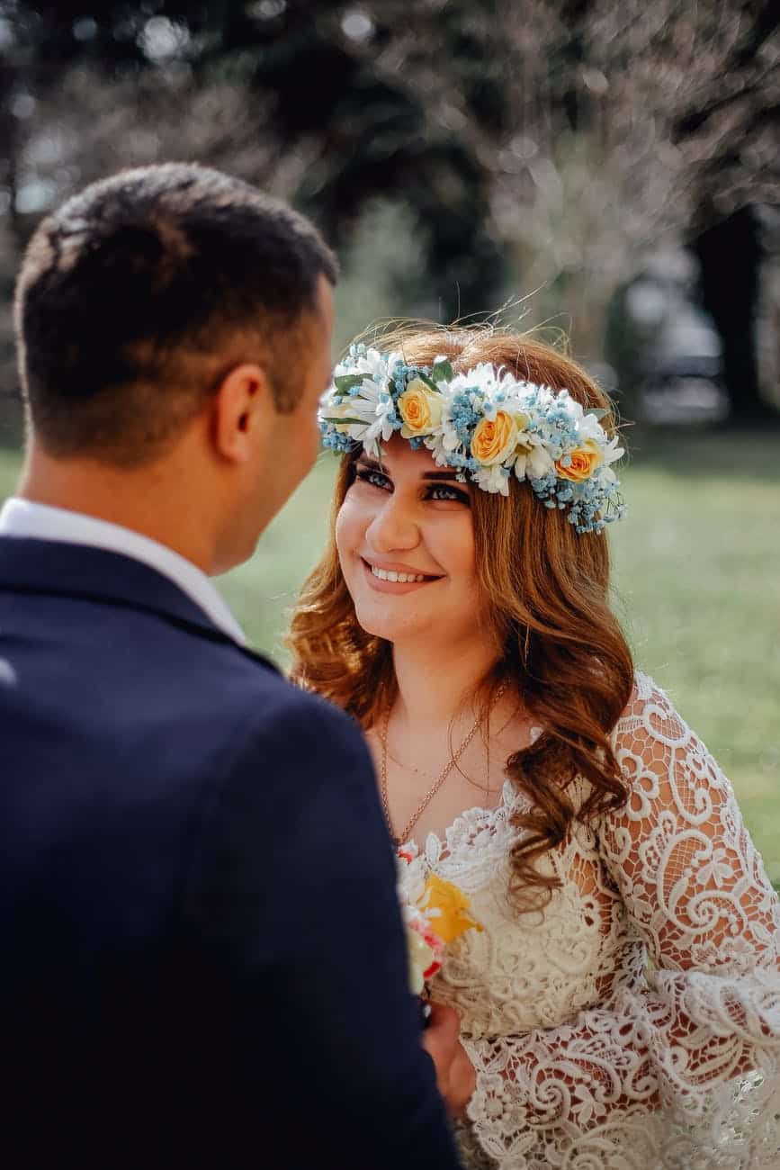 newlywed couple smiling to each other in park