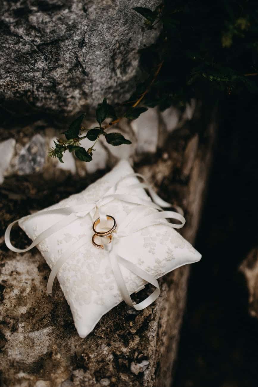 two gold rings on a silk cushion