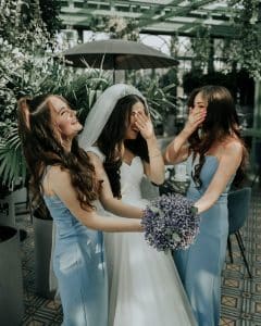 bride holding bouquet of flowers with her bridesmaids