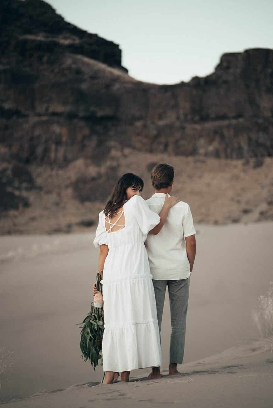 romantic barefoot couple on sandy terrain