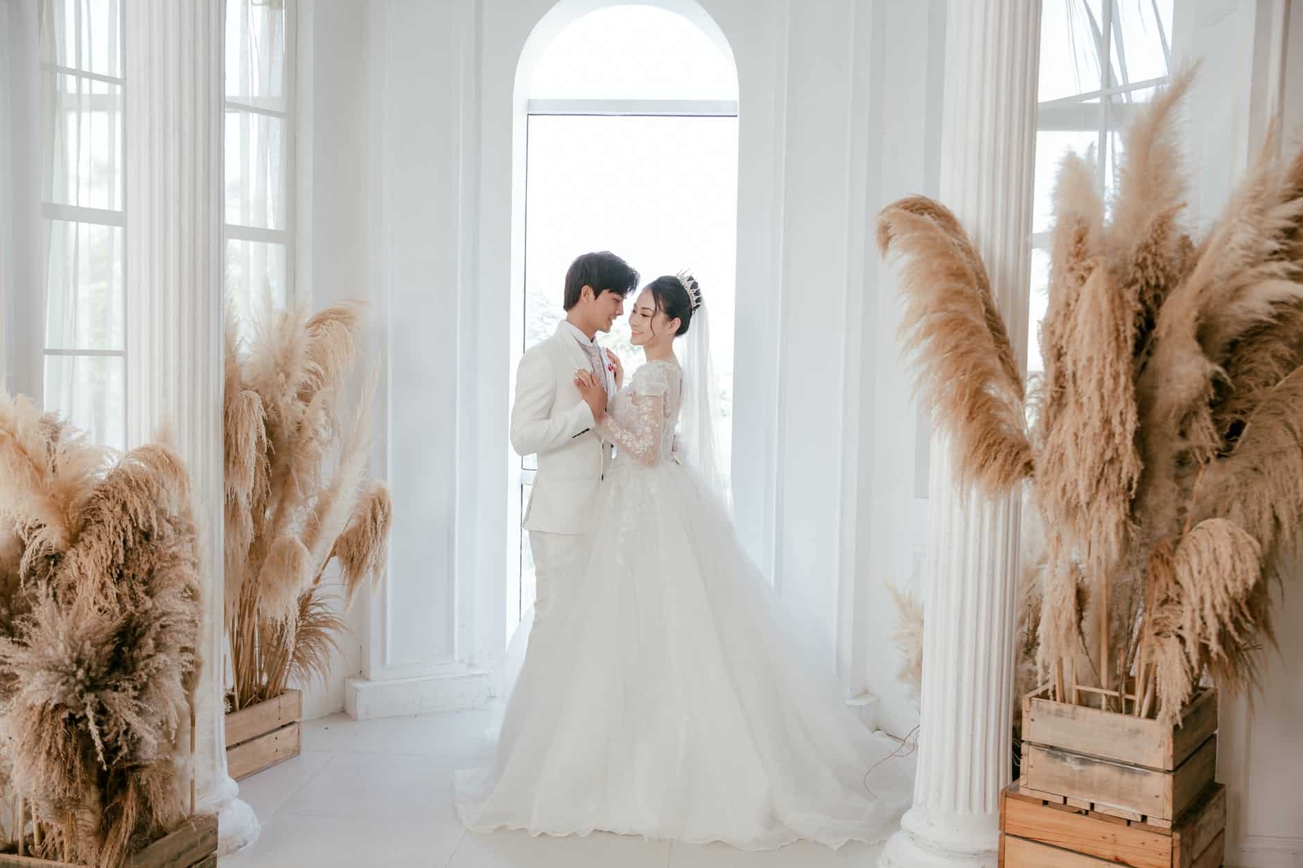 happy asian newlyweds embracing during wedding day
