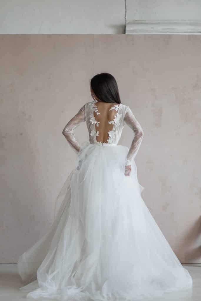 Robe de mariée féérique en tulle avec manches longues, dos ouvert.