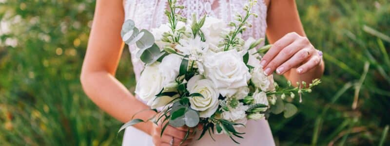 mariée qui tient un bouquet qui fait partie des accessoires indispensables pour la mariée