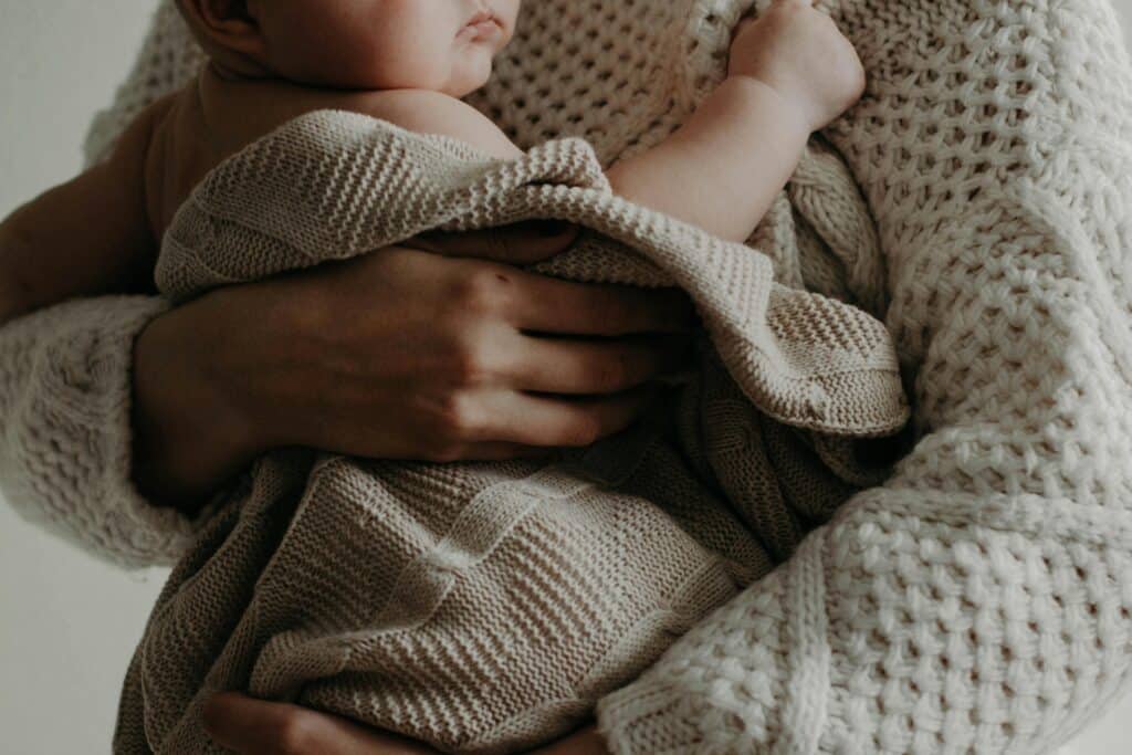 photo d'un bébé dans les bras de sa maman qui montre que peu importe le choix de la péridurale ou non du moment que l'enfant est en bonne santé