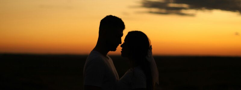 Un couple face à face au coucher de soleil