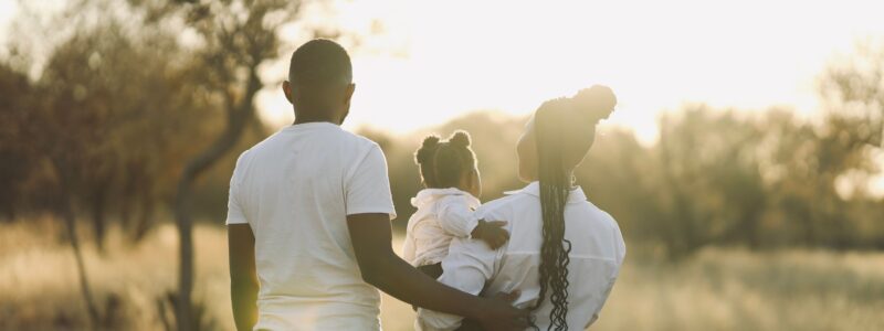 famille en promenade en extérieur avec un papa, une maman et une petite fille