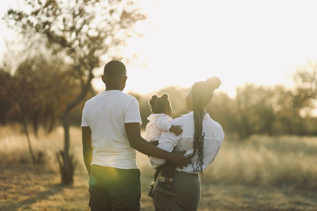 famille en promenade en extérieur avec un papa, une maman et une petite fille