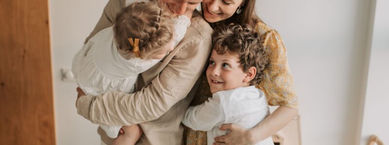 parents entourés de leurs enfants où ils se font tous un câlin